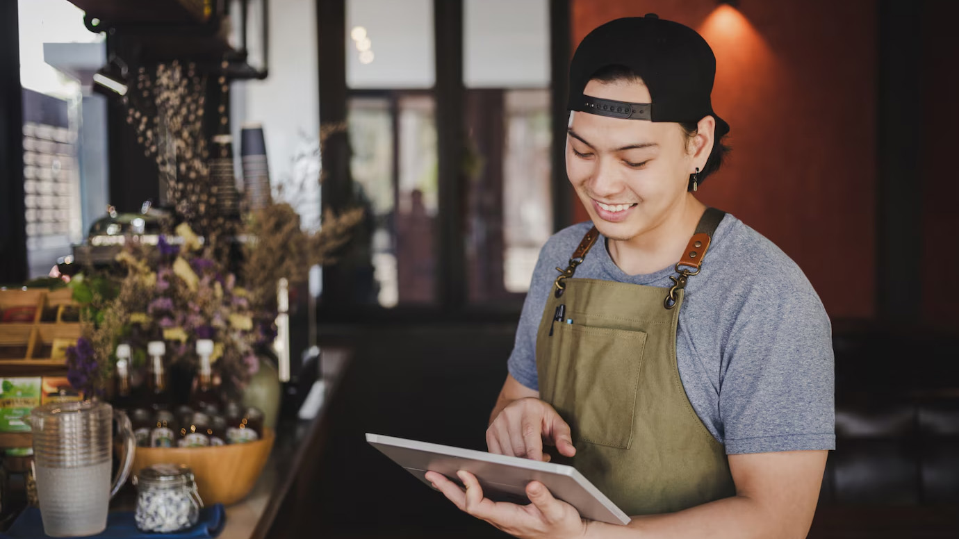 Asisn man holding PayRecon POS System
