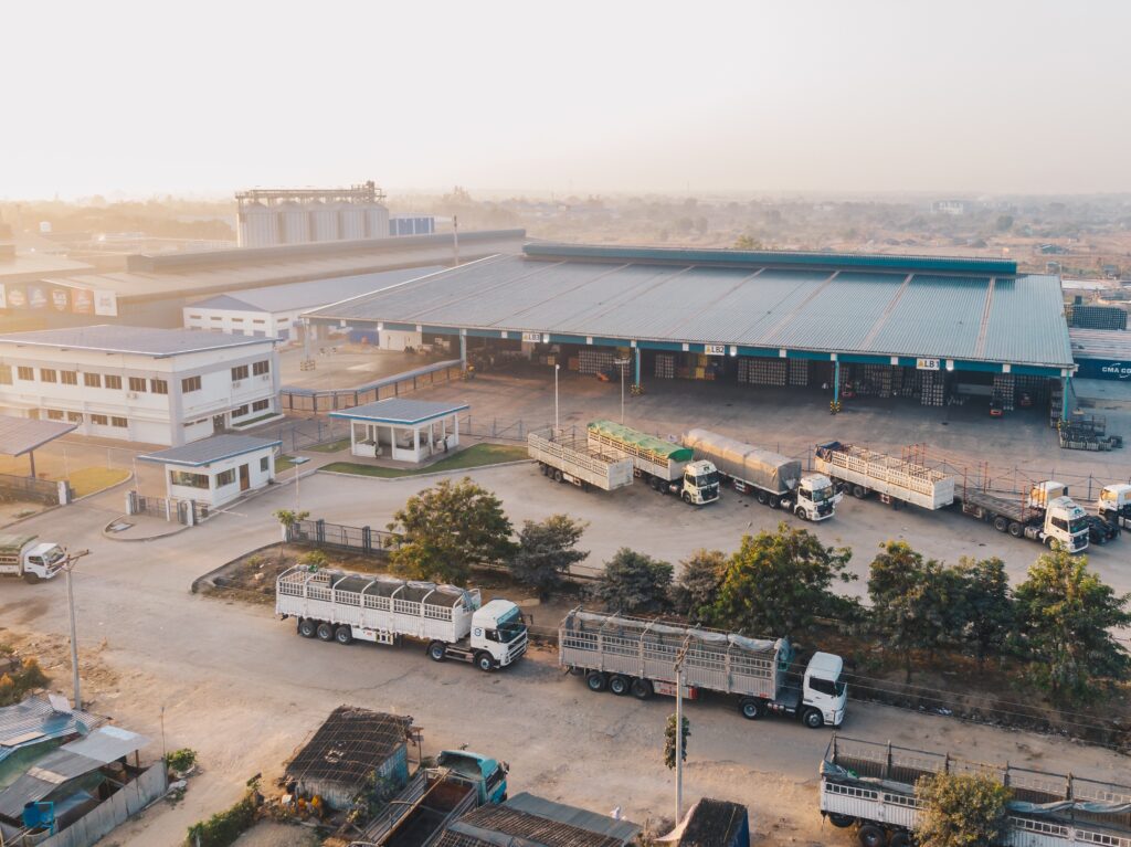Aerial shot of factory trucks parked near the warehouse at daytime