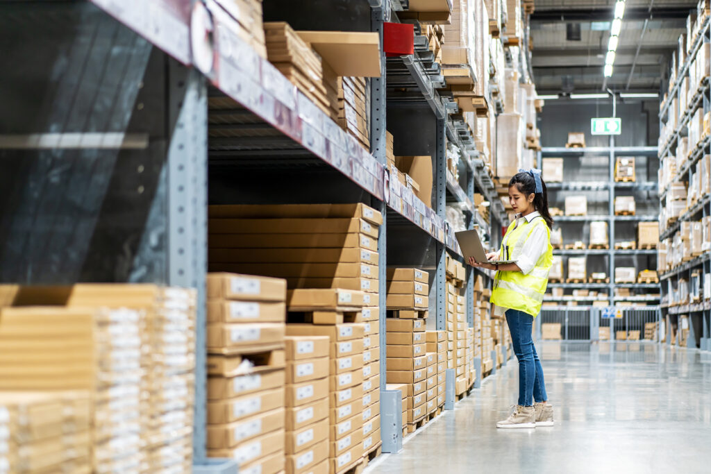 SS Motor Warehouse picker check stock details on tablet computer for checking boxes with logistics on shelves with goods background in warehouse