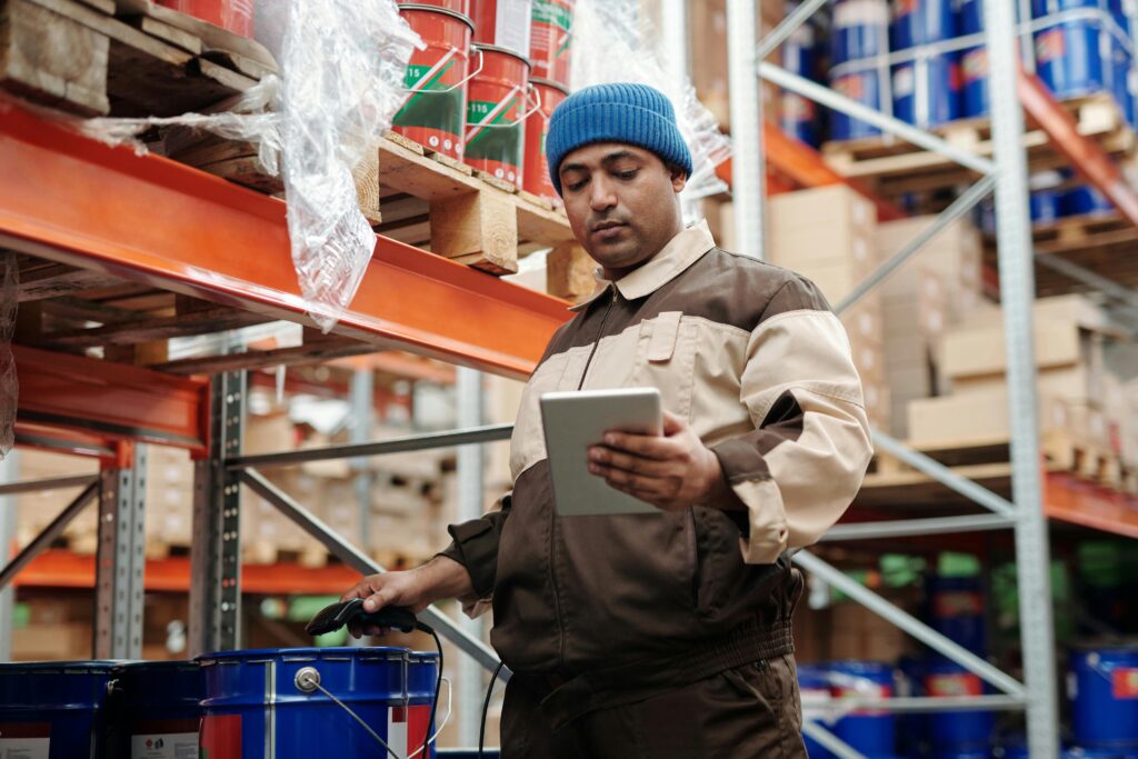 Warehousing staff is holding tablet on hand and checking for product allocation