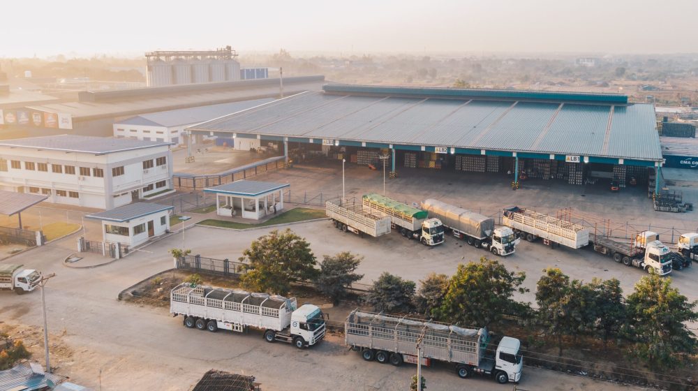 Aerial shot of factory trucks parked near the warehouse at daytime