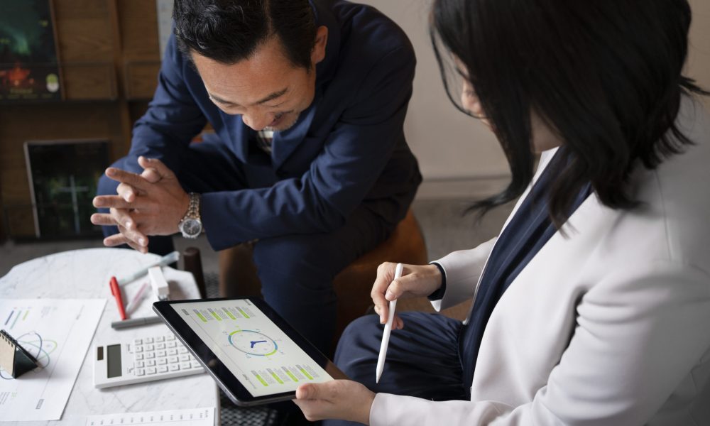 Consultant guiding a business team through software deployment, with workflow diagrams and strategy discussion in the background.
